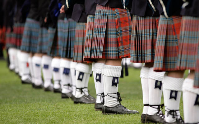 A Row Of Men Wearing Kilts.